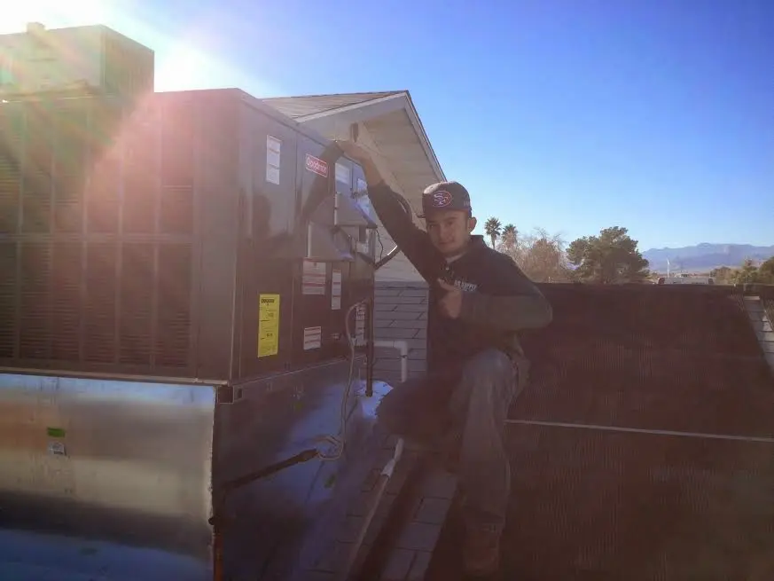 HVAC technician performing Heat Pump Repair on a rooftop unit in Morrilton